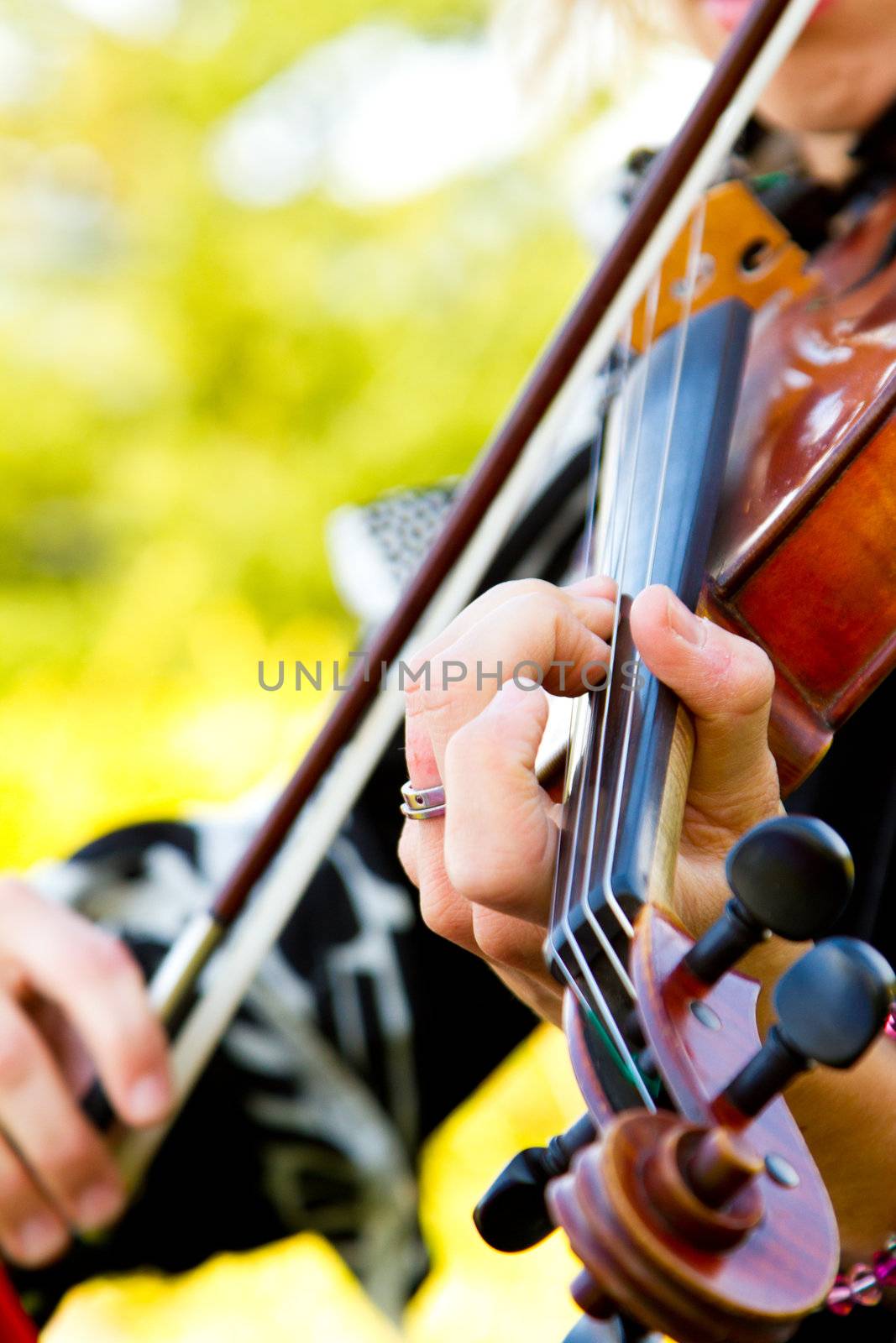 A close-up detail of a woman playing the violin at a wedding.