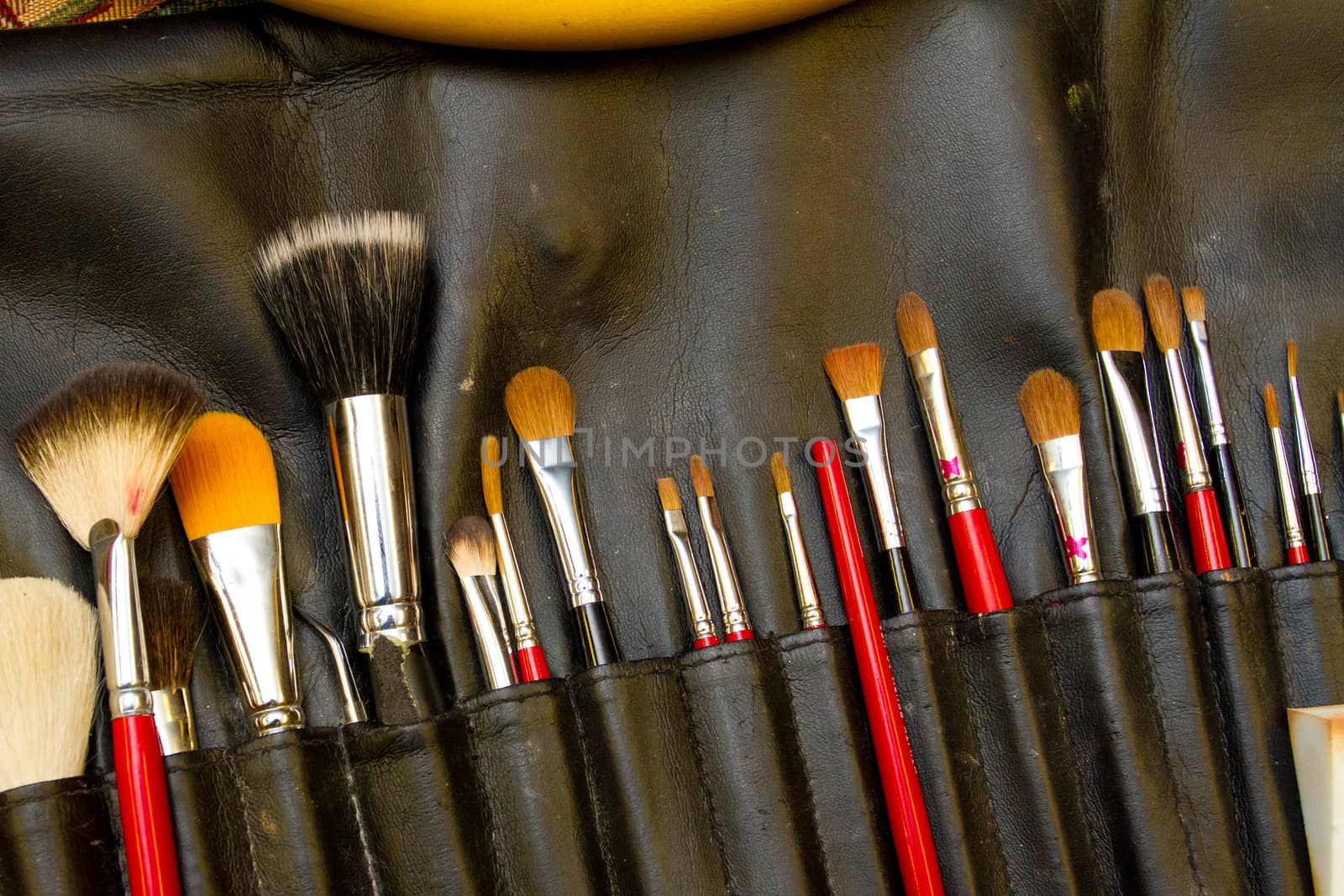 Makeup brushes in a container for wedding makeup and styling.