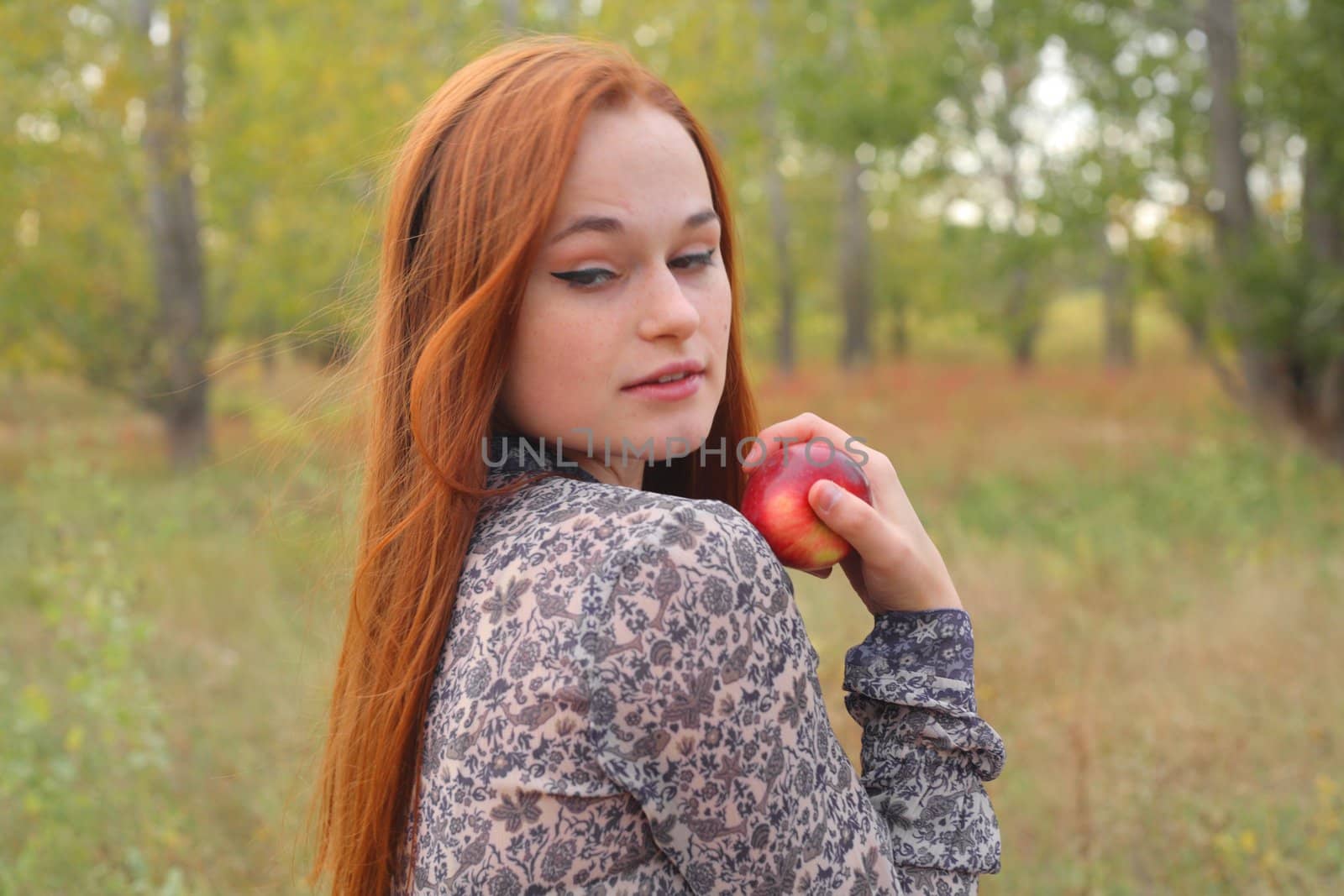 portrait of young woman holding red apple in hand by mettus
