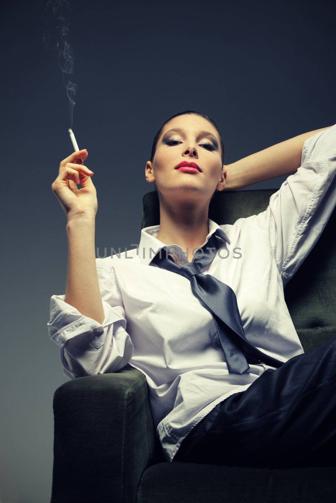 Sensual woman smoking a cigarette, fashion model portrait