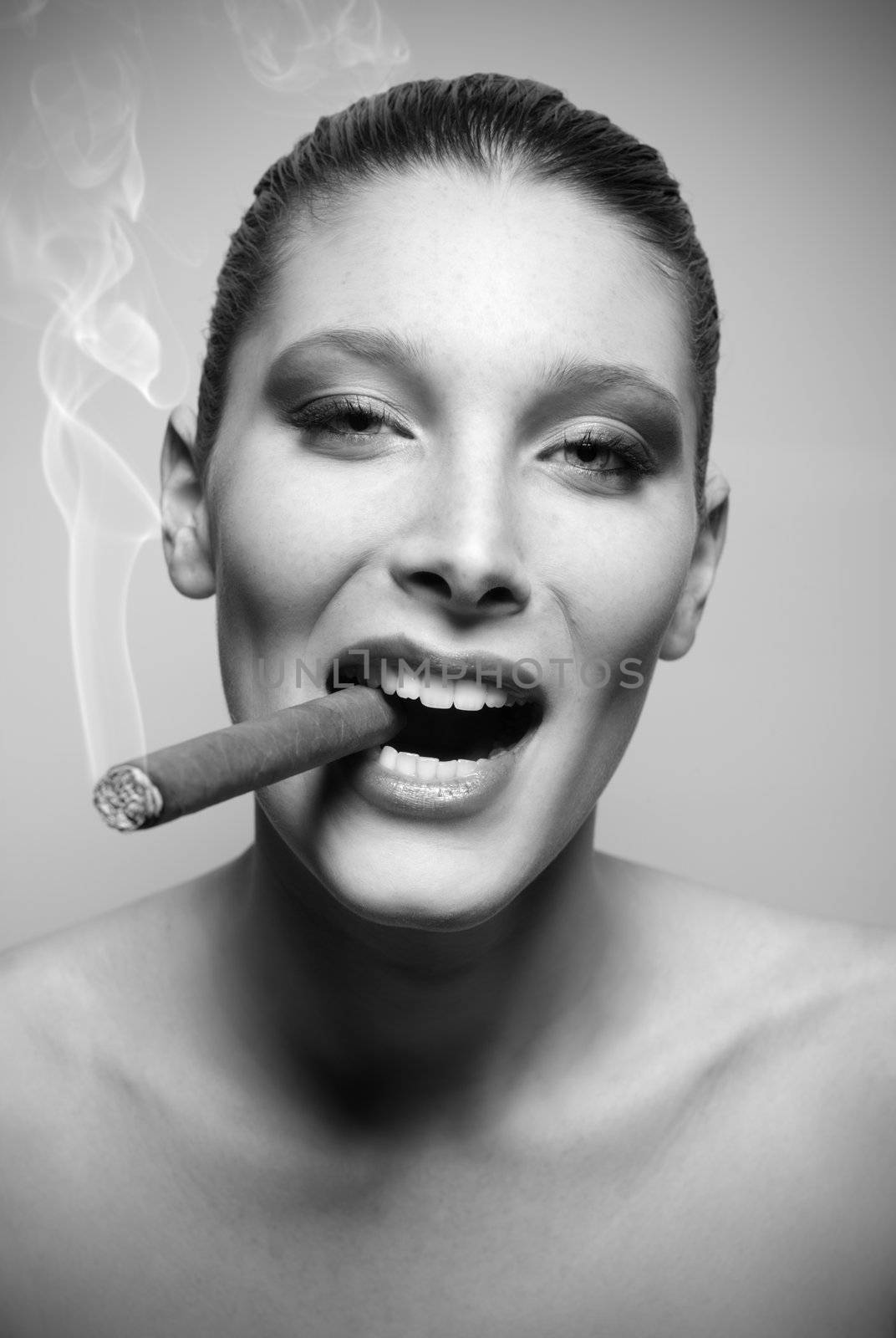 Attractive young woman smoking a cigar, portrait of fashion model