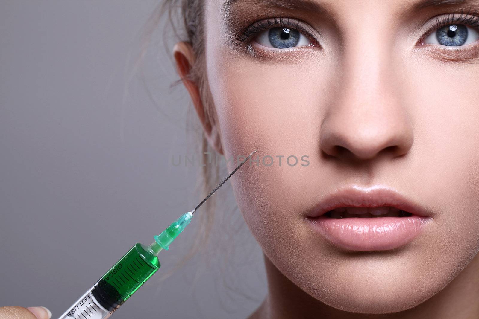 Close up of beautiful woman gets an injection in her face