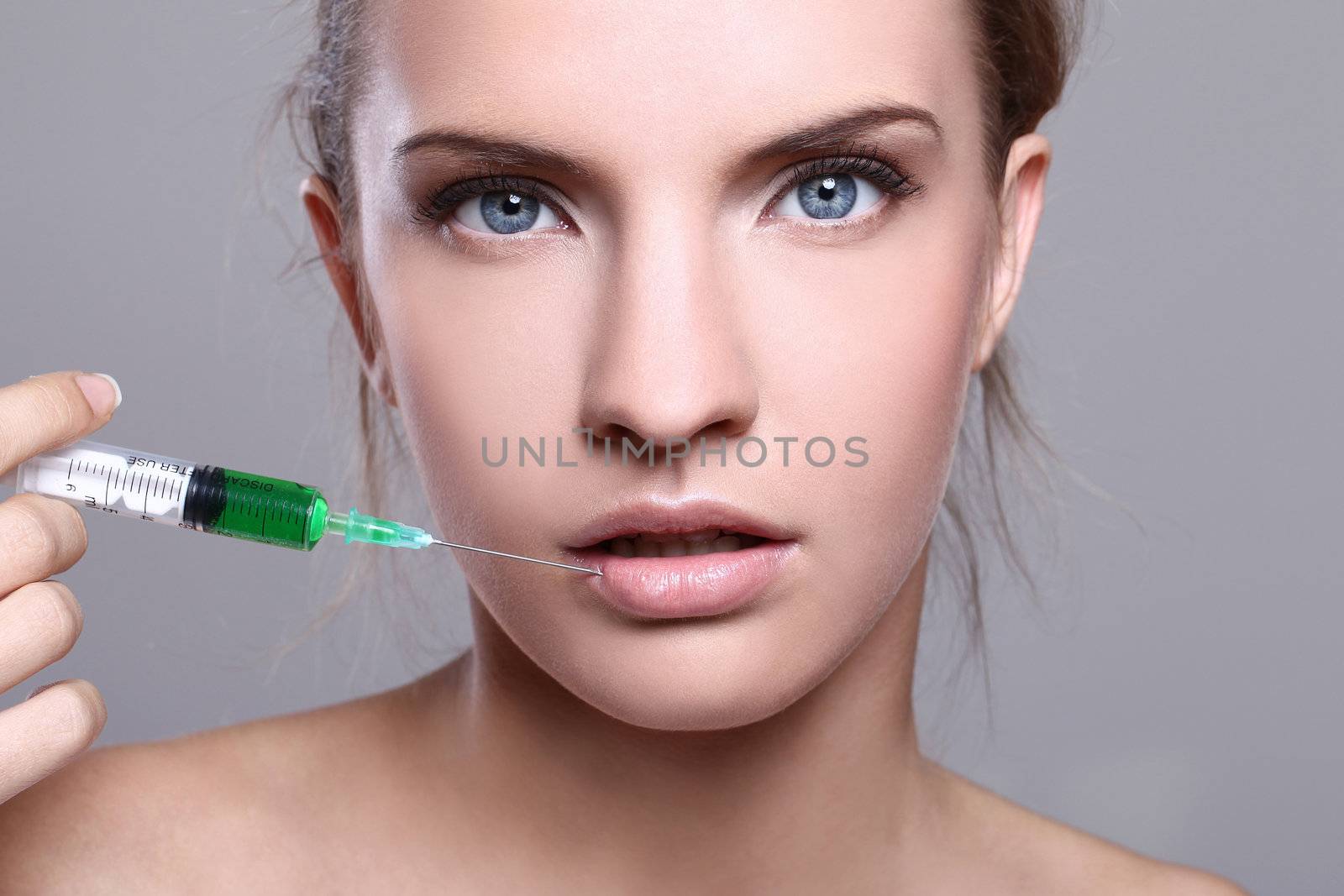 Close up of beautiful woman gets an injection in her face