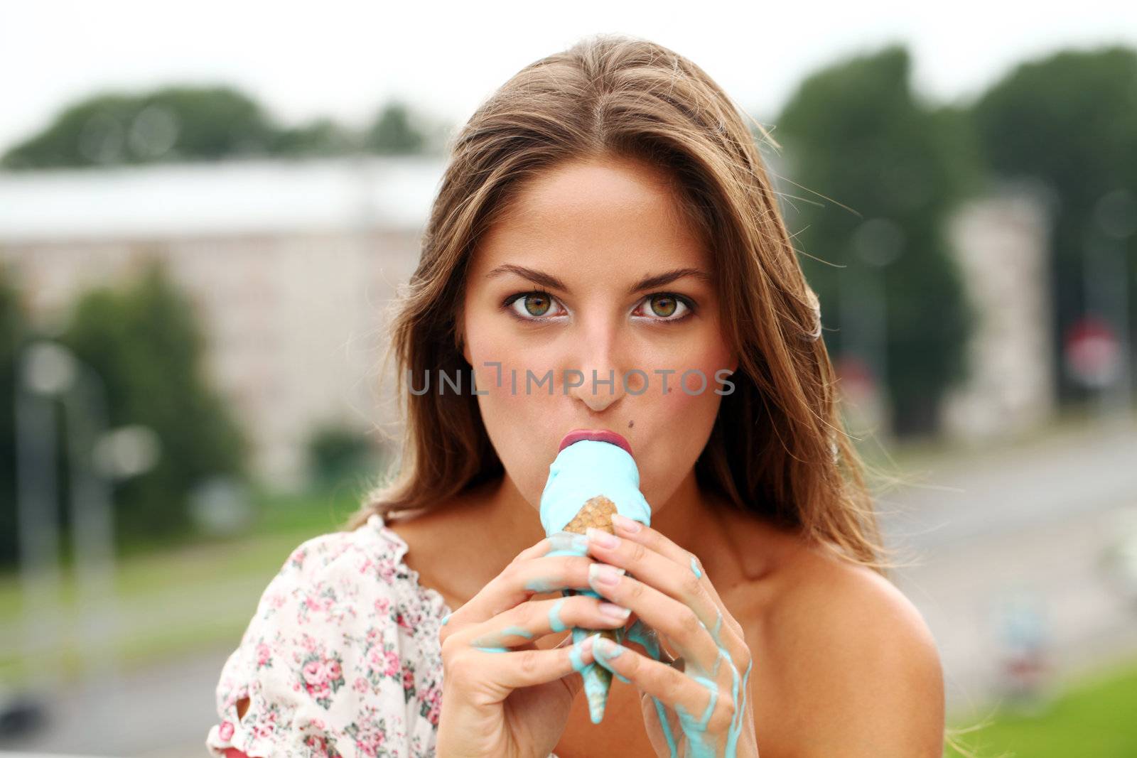 Young and attractive girl eating icecream on a street