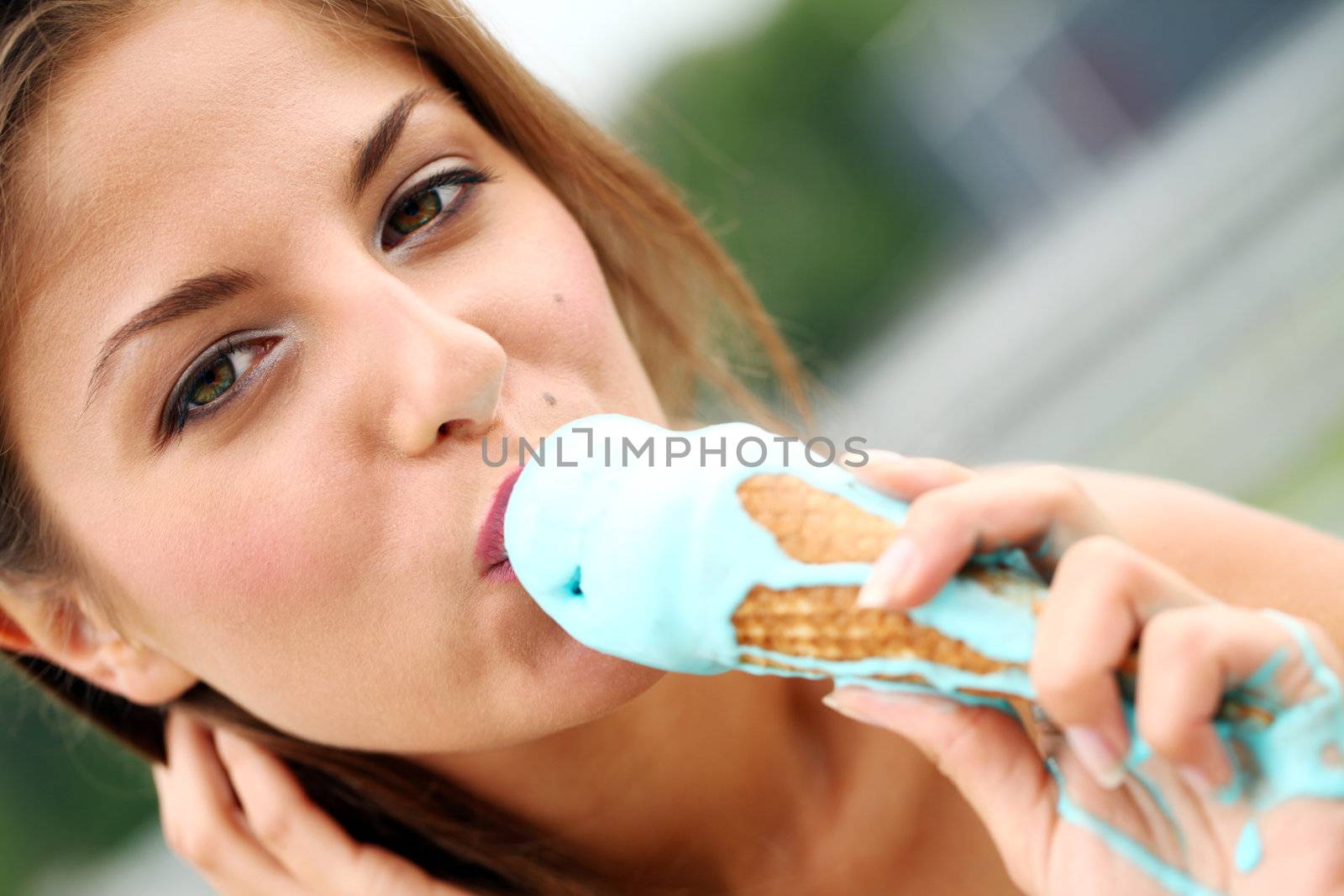 Young and attractive girl eating icecream on a street