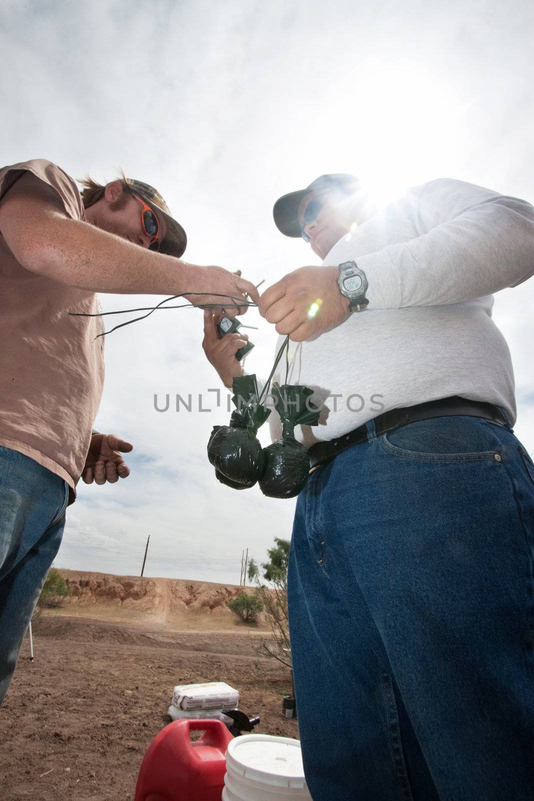 Special effects crew members tying bags of explosive powder