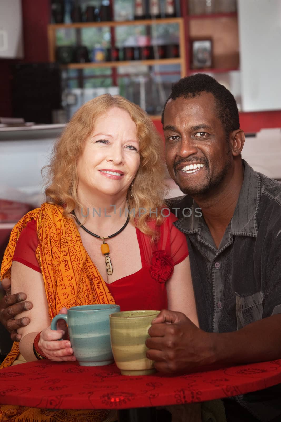 Happy mixed Black and white mature couple in cafe