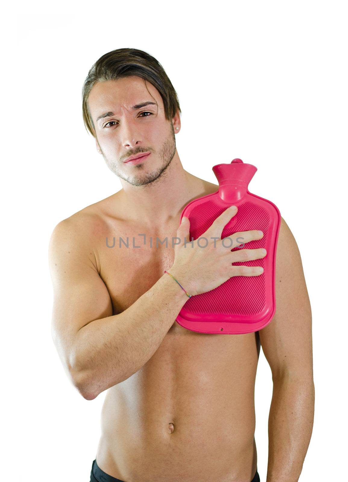 Handsome young man with shoulder pain, holding hot water bottle by artofphoto