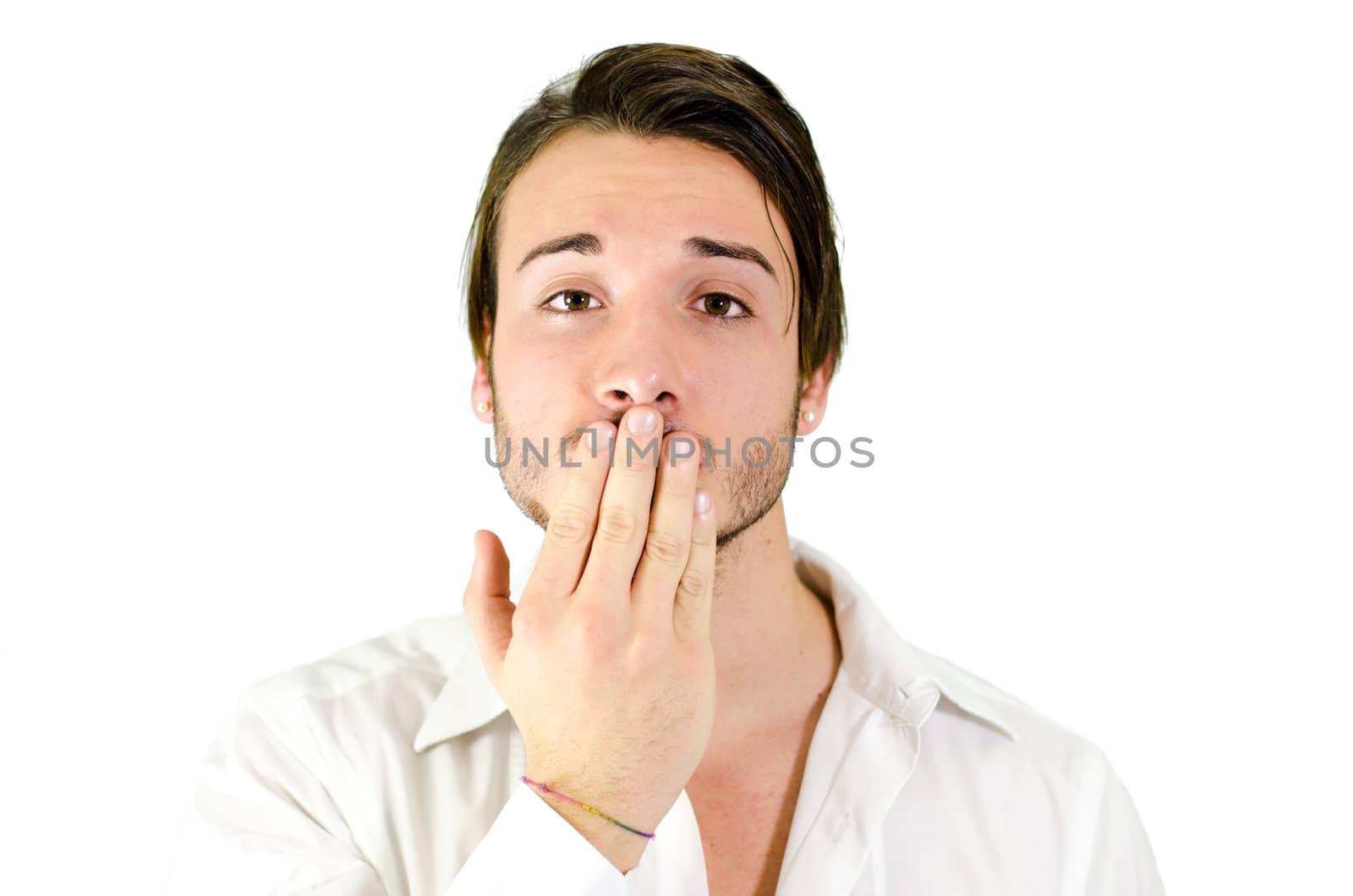 Young man covering mouth with hand, should not speak by artofphoto