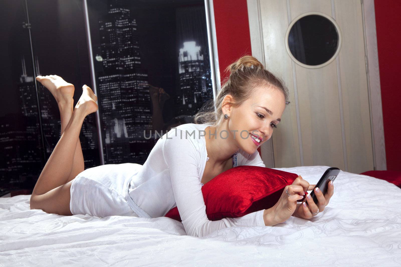 woman lying on bed with mobile phone l by ssuaphoto