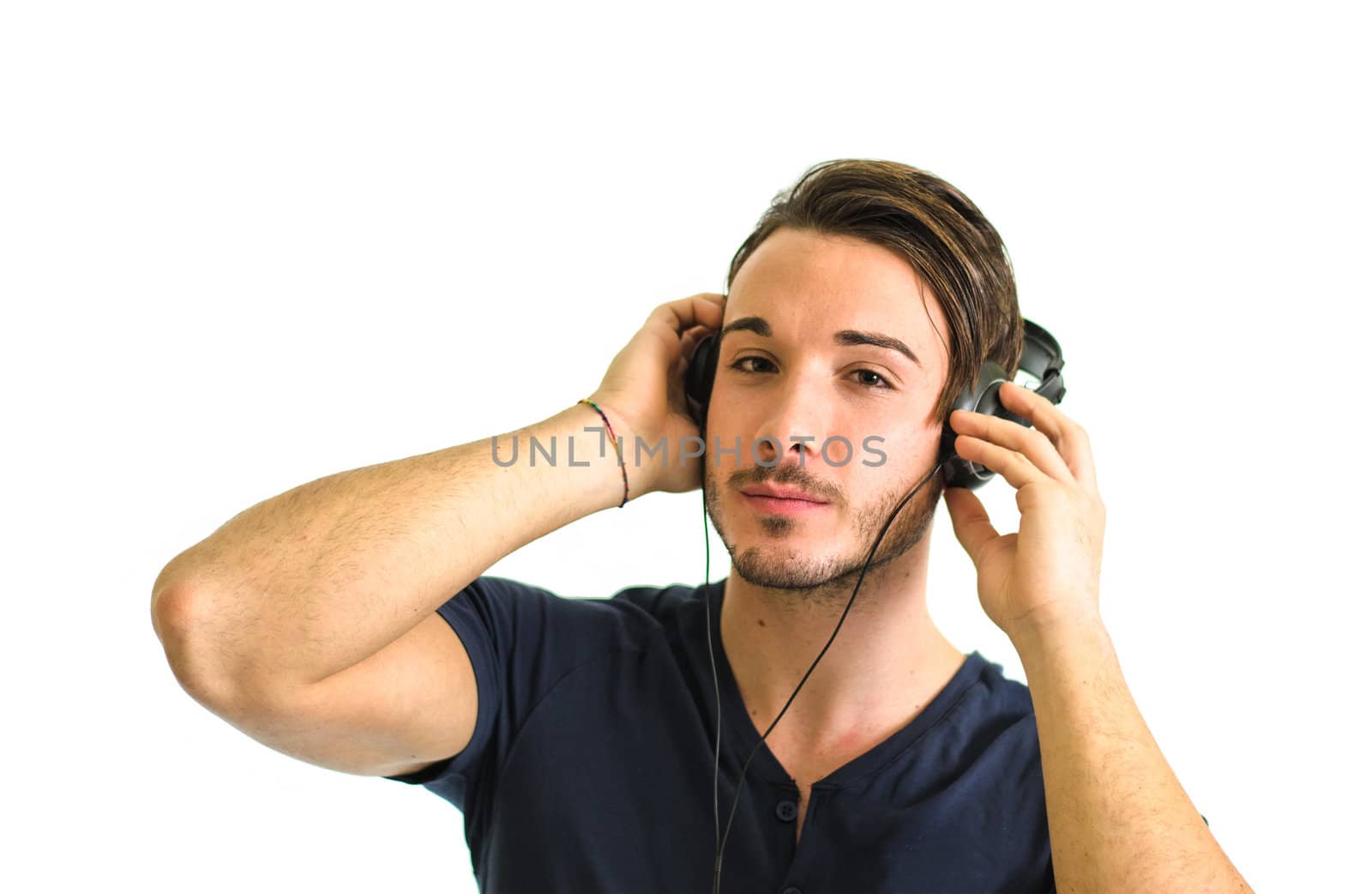 Attractive young man with headphones listening to music isolated on white