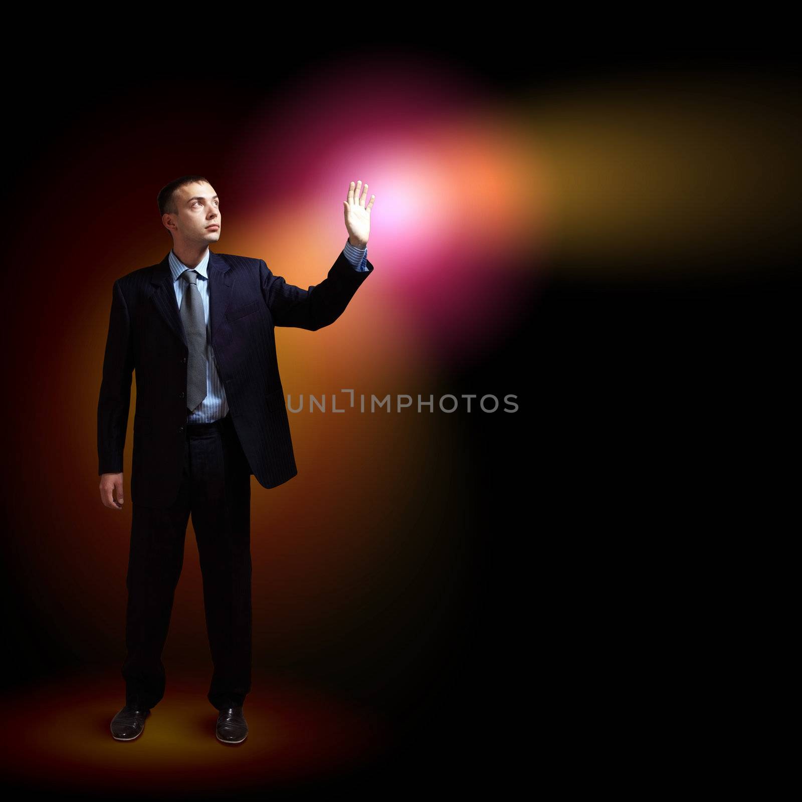 Young successful businessman holding a shining light in his hand as a symbol of success and advancement.