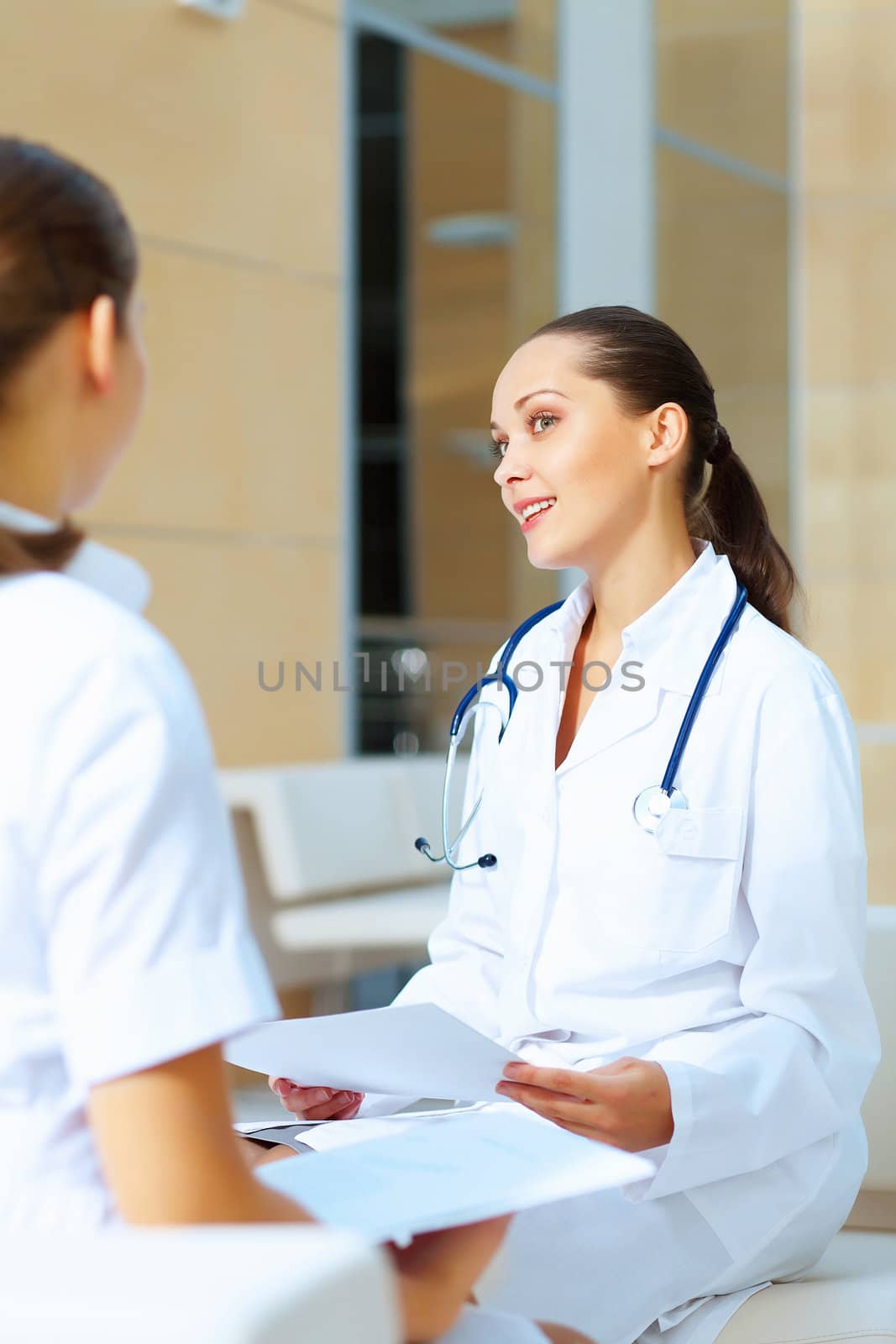 Portrait of two friendly female doctors in hospital discussing something