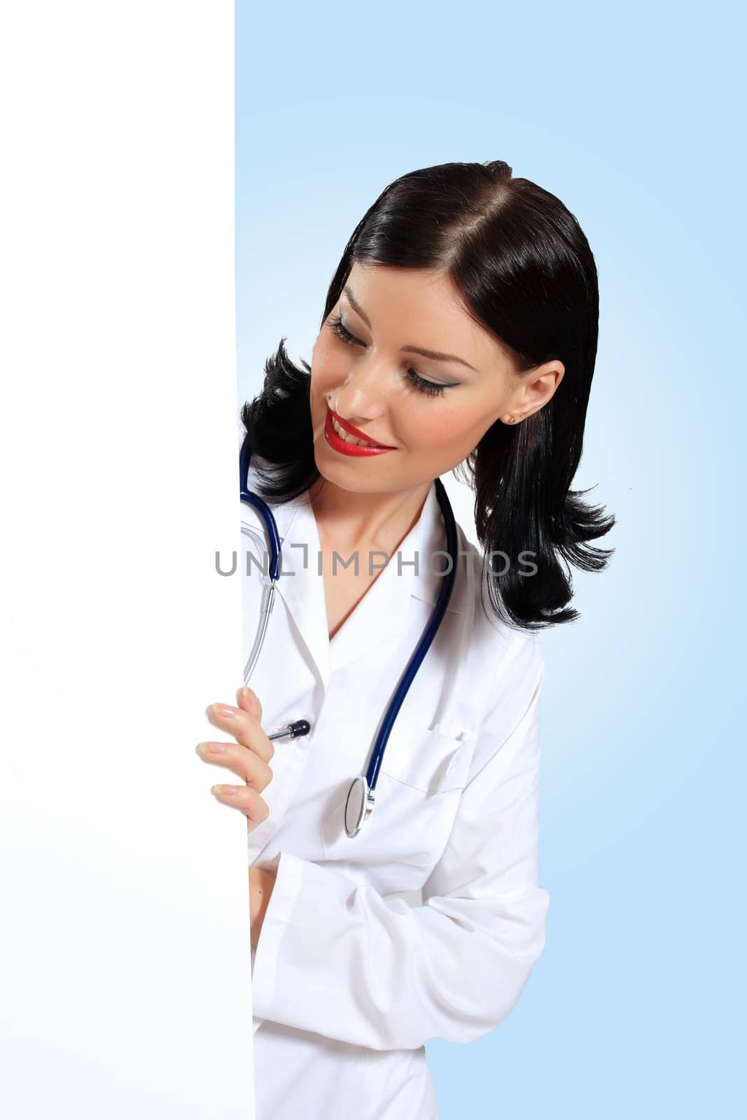 Portrait of happy successful young female doctor holding blank banner