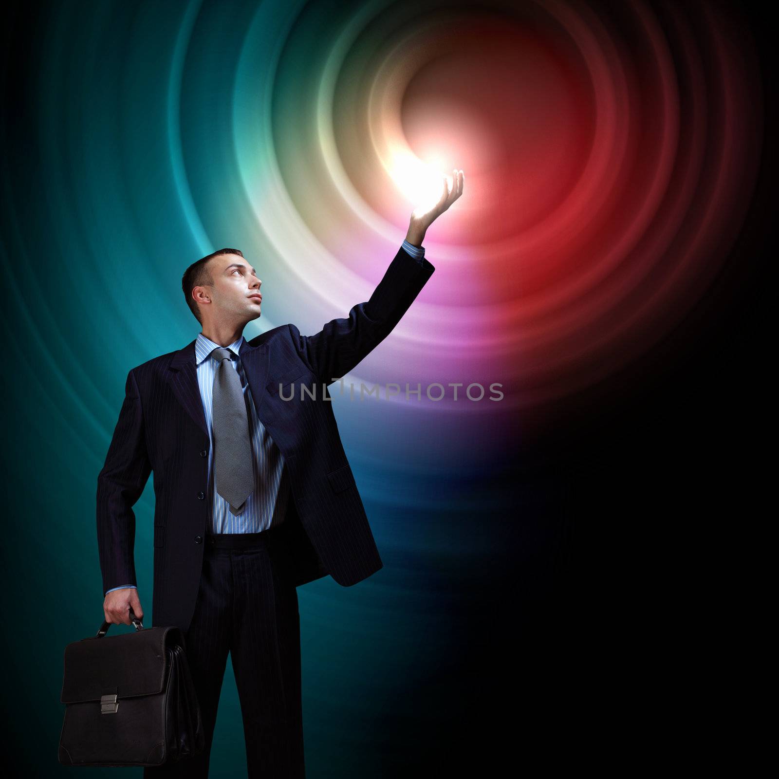 Young successful businessman holding a shining light in his hand as a symbol of success and advancement.