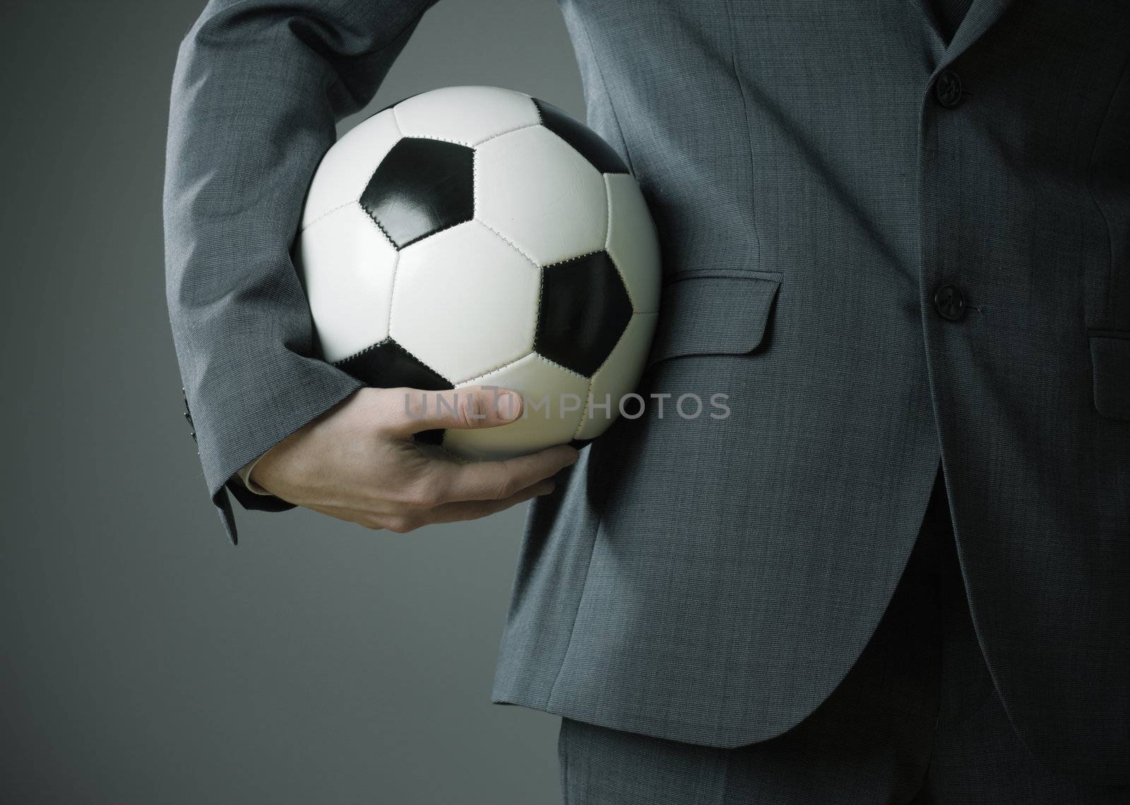 Elegant businessman holding a soccer ball by stokkete