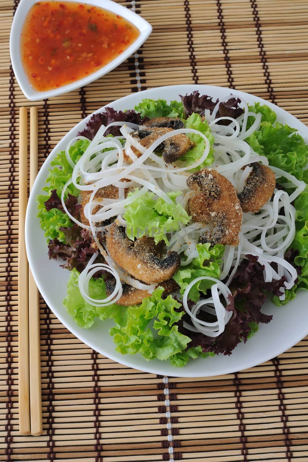 Rice noodles with mushrooms in breadcrumbs in lettuce leaves by Apolonia