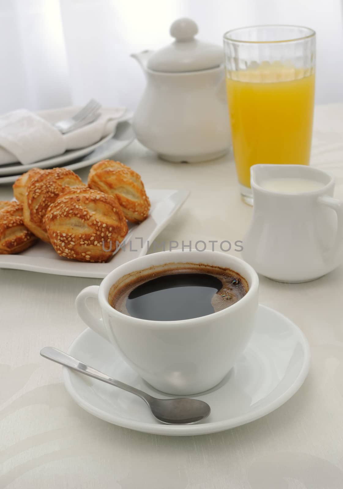 Morning cup of coffee with freshly baked rolls with sesame seeds, juice and milk