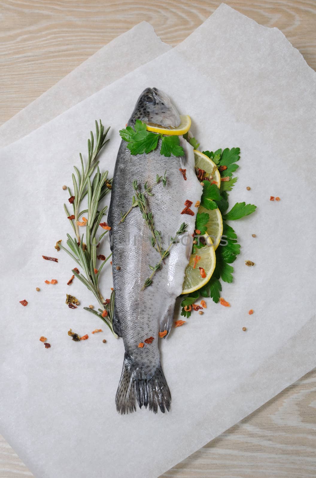Fresh trout with lemon and spices on paper