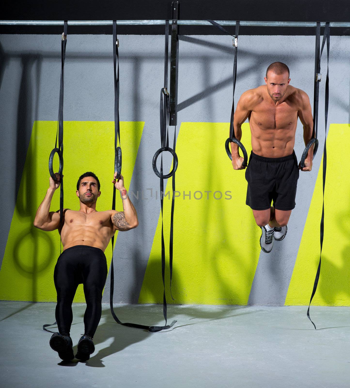 Crossfit dip ring two men workout at gym dipping by lunamarina