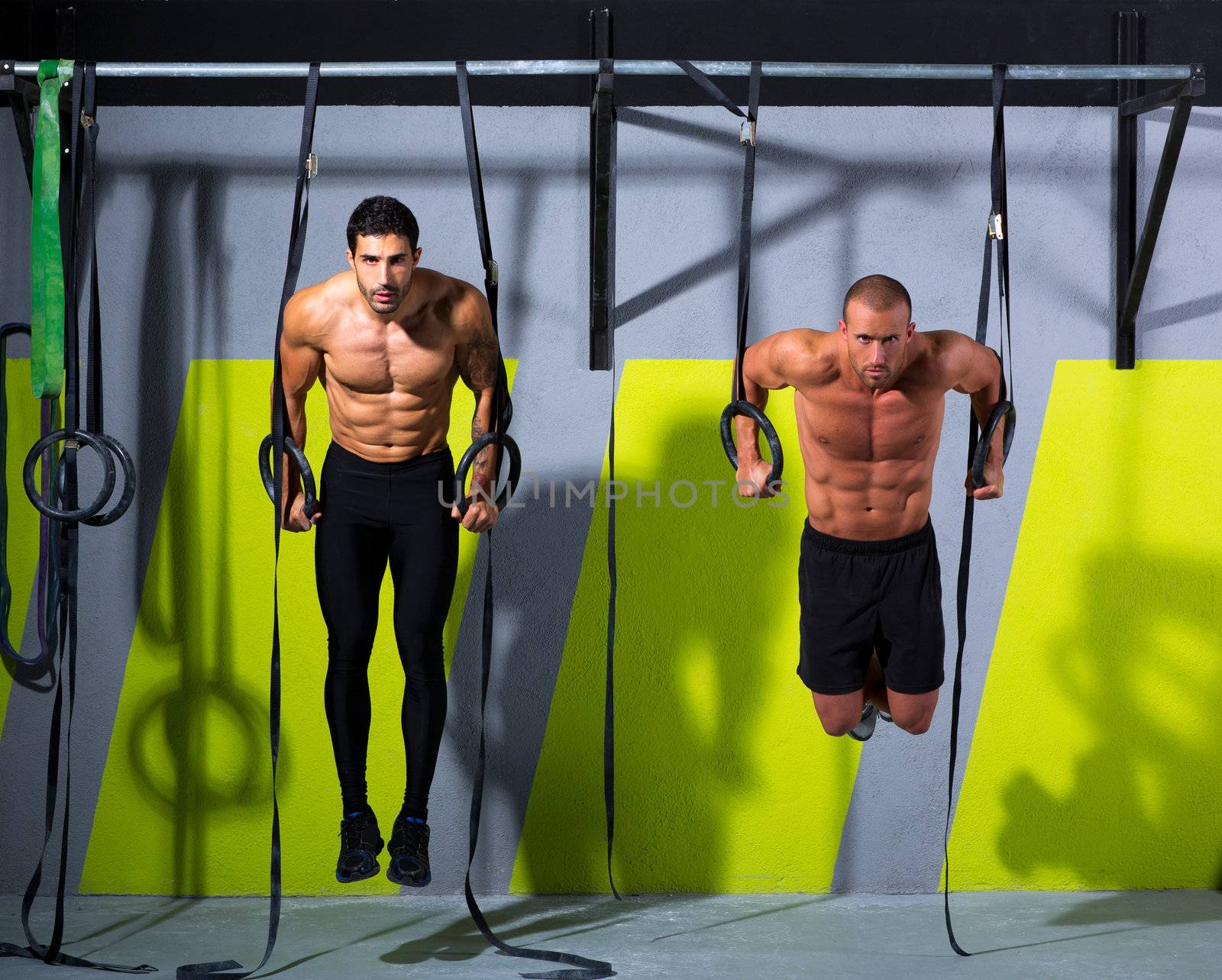 Crossfit dip ring two men workout at gym by lunamarina