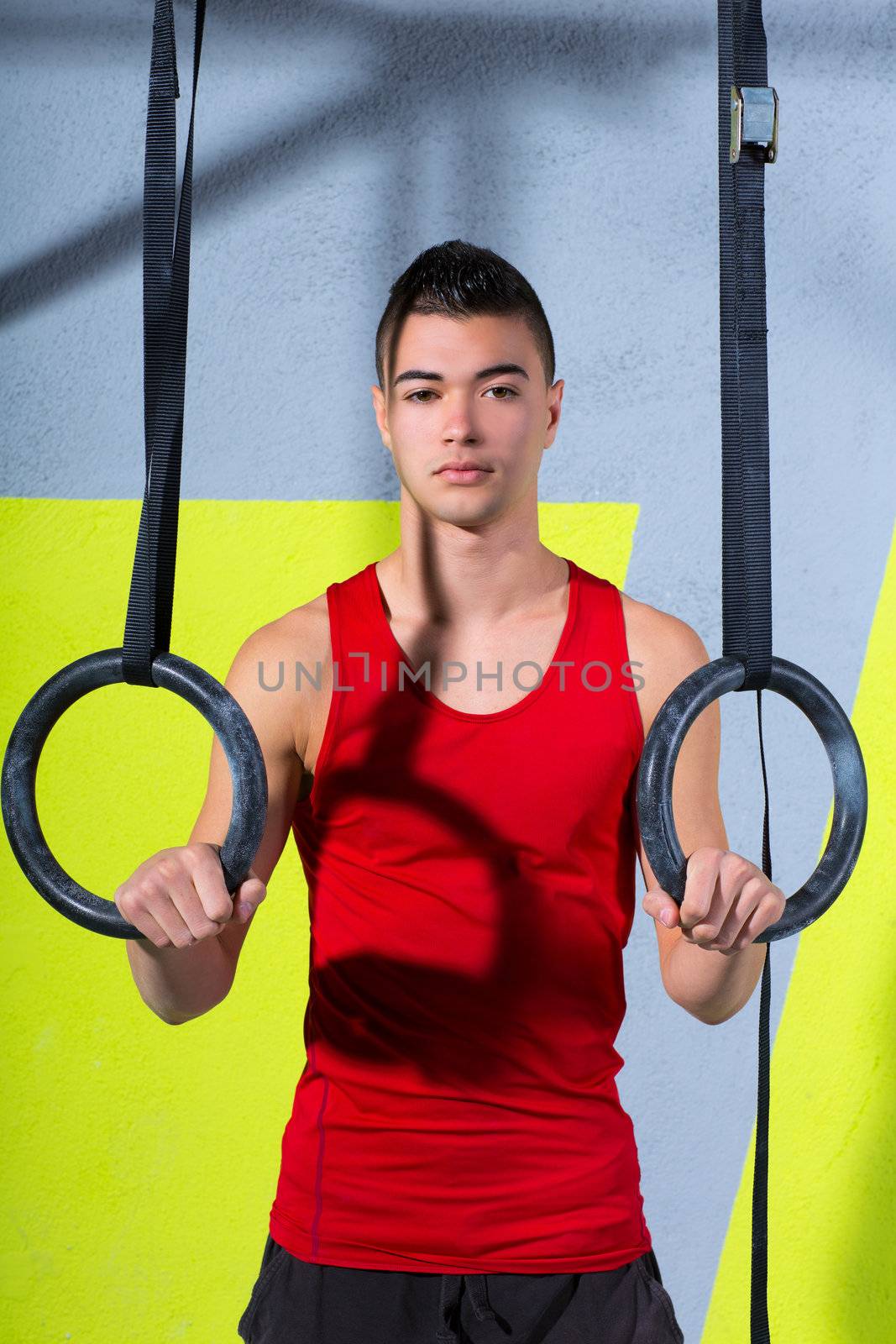 Crossfit dip ring young man relaxed after workout at gym dipping exercise