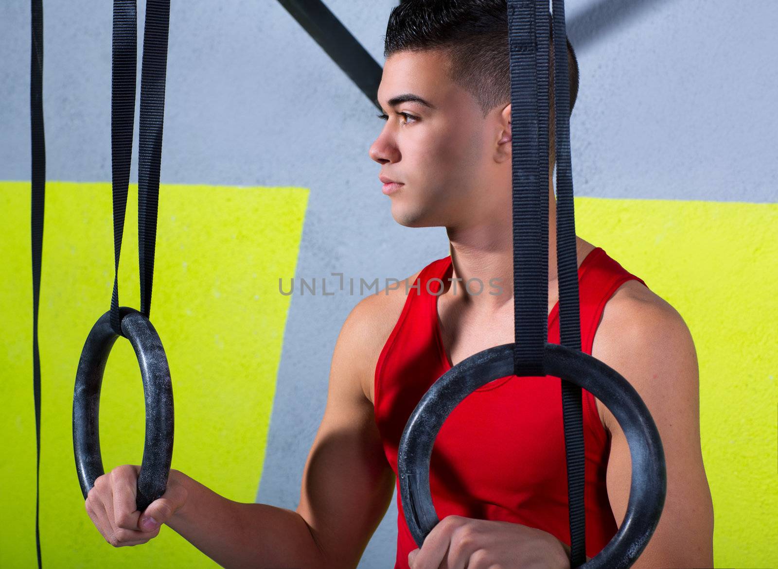 Crossfit dip ring young man relaxed after workout at gym dipping exercise