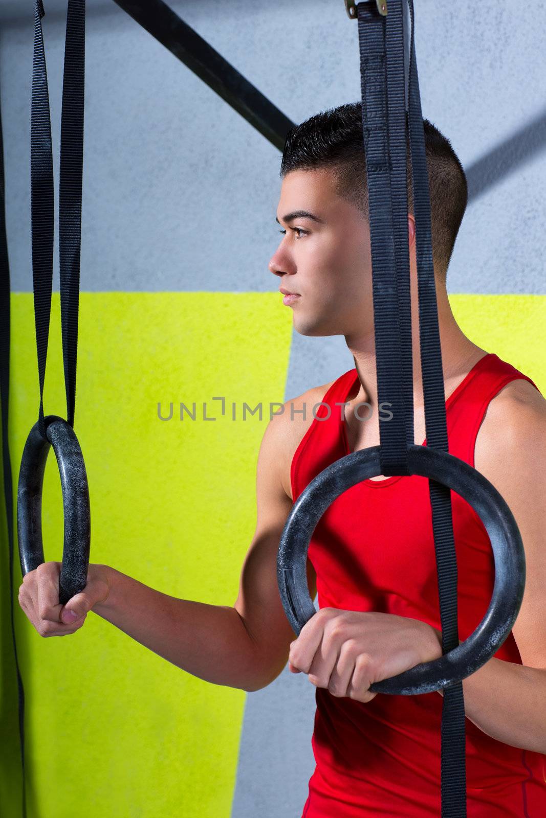 Crossfit dip ring young man relaxed after workout at gym dipping exercise