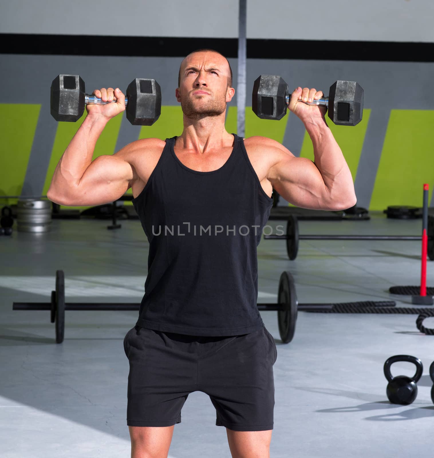 Gym man with dumbbells exercise crossfit by lunamarina