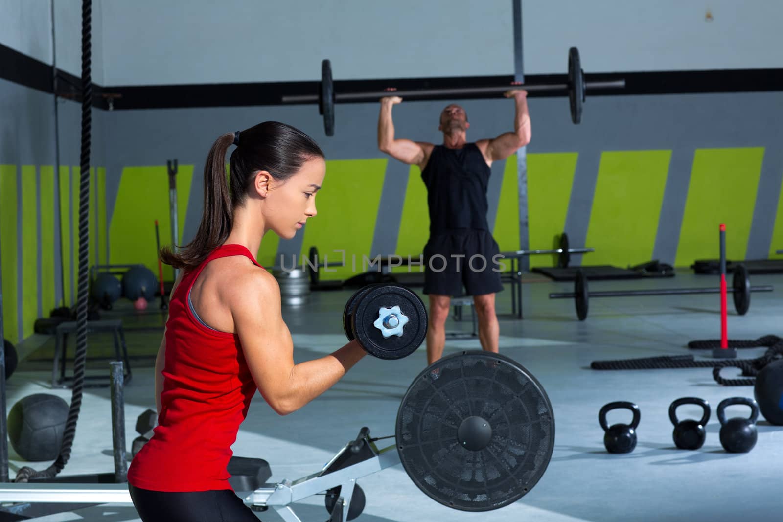 girl dumbbell and man weight lifting bar workout by lunamarina