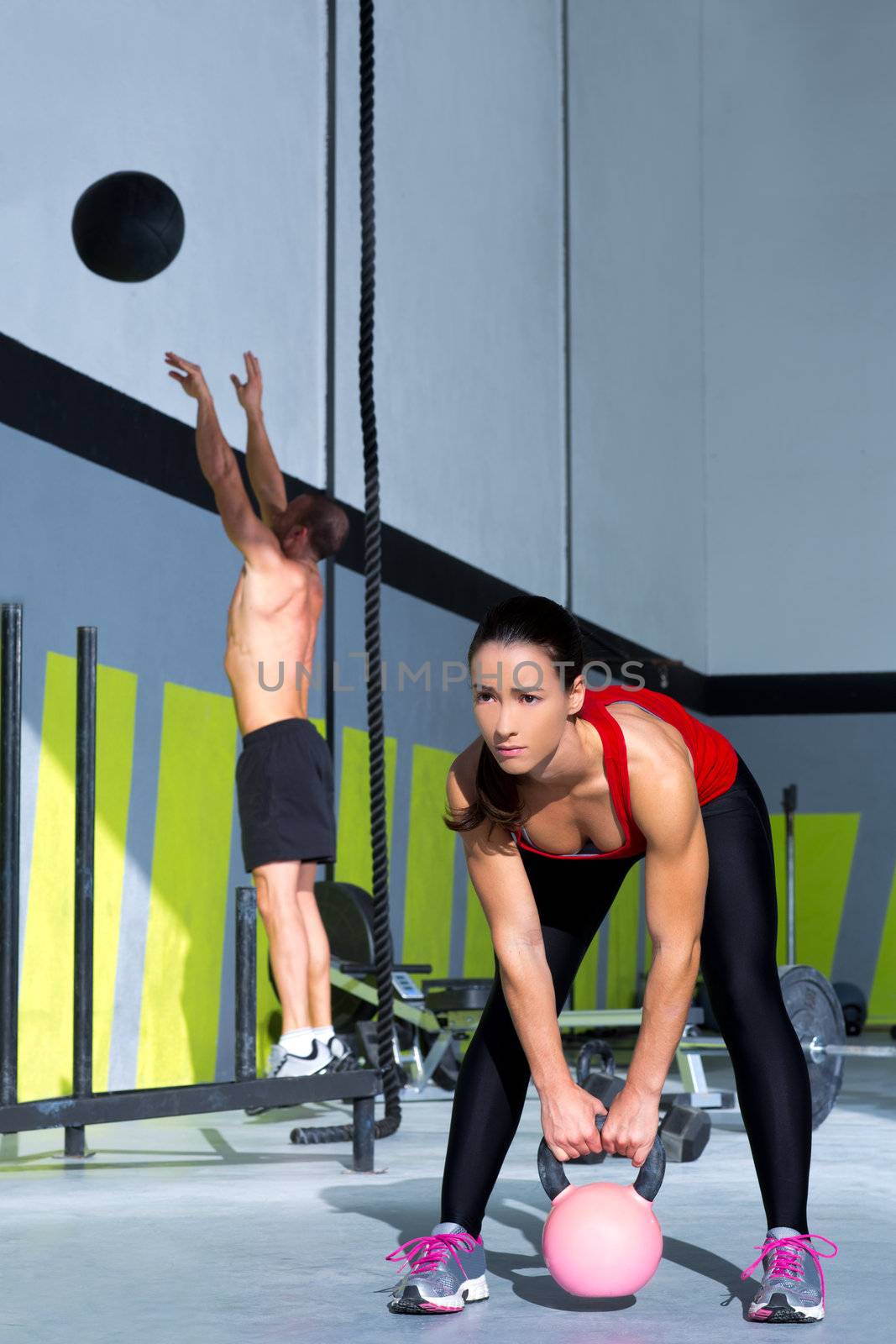 Crossfit gym Kettlebell woman and jumping wall ball man workout at gym
