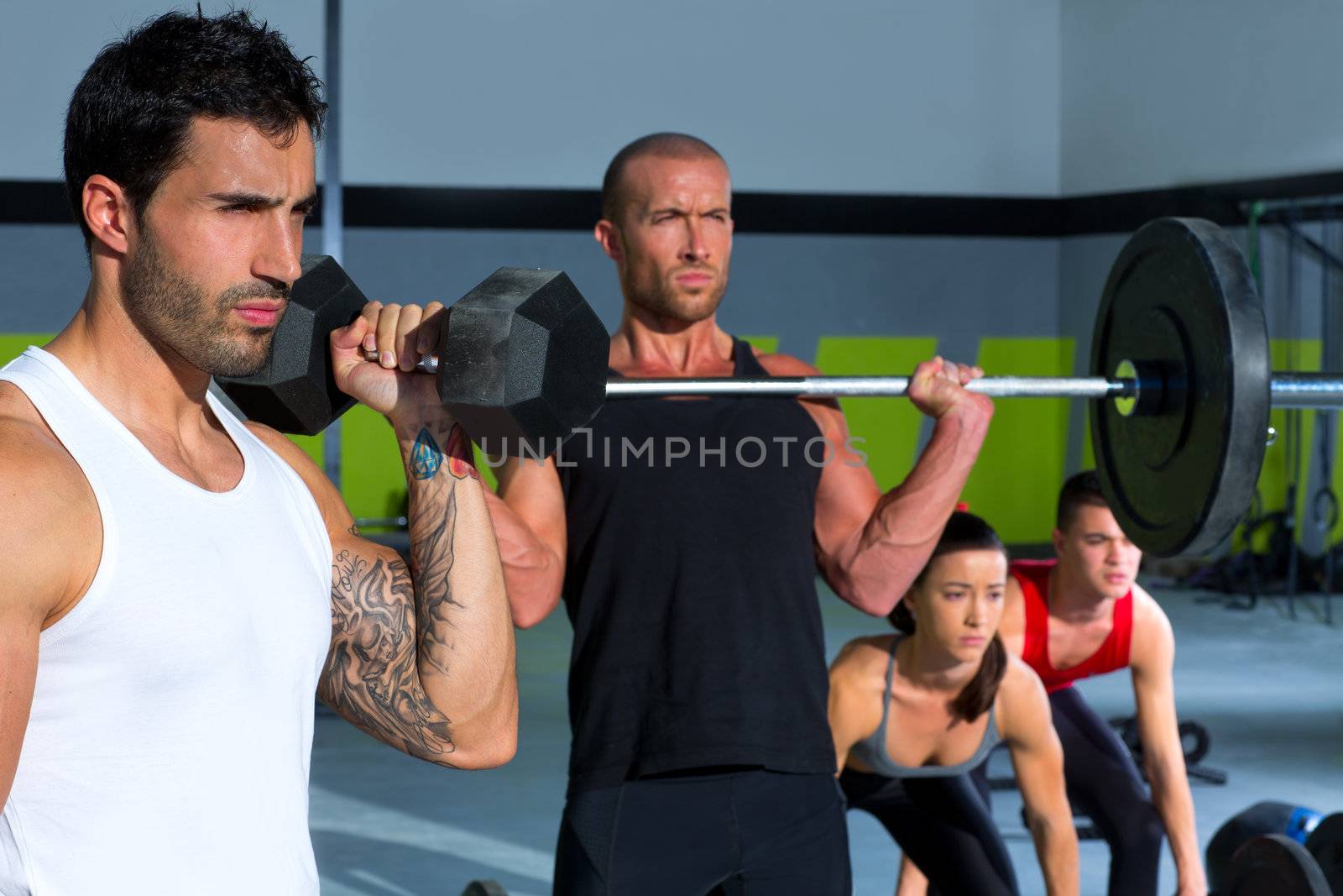 gym group with weight lifting bar and dumbbells workout in crossfit exercise