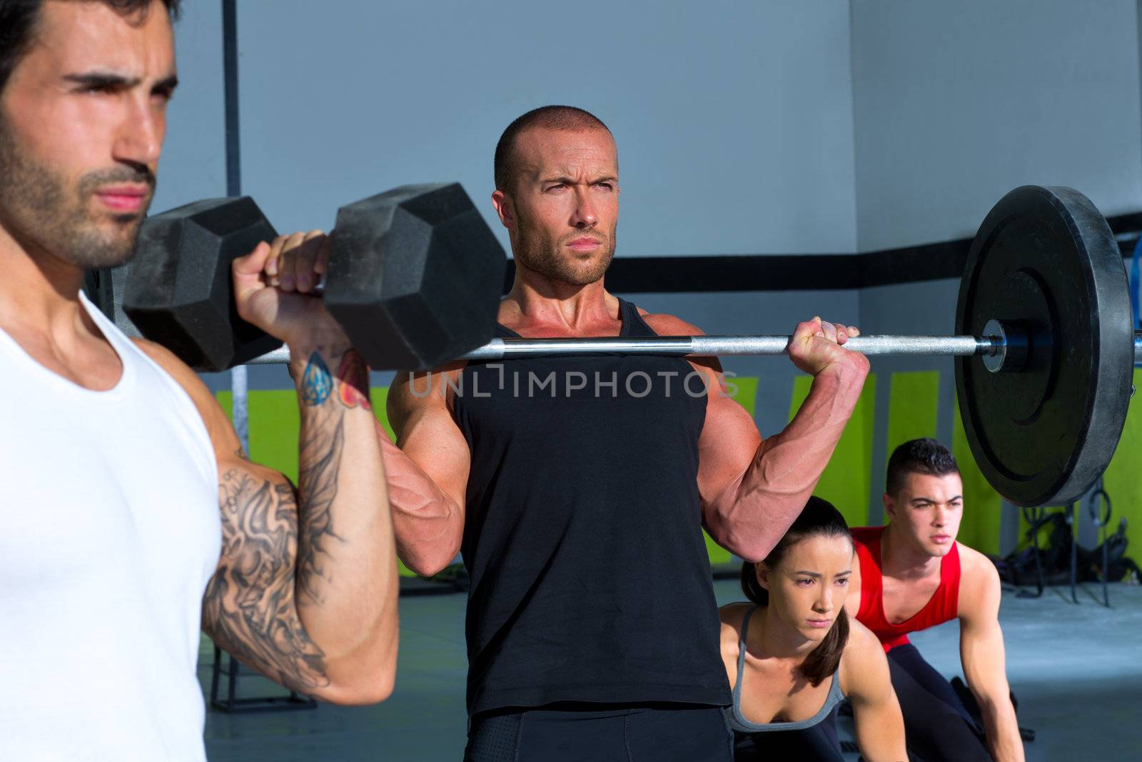 gym group with weight lifting bar and dumbbells workout in crossfit exercise