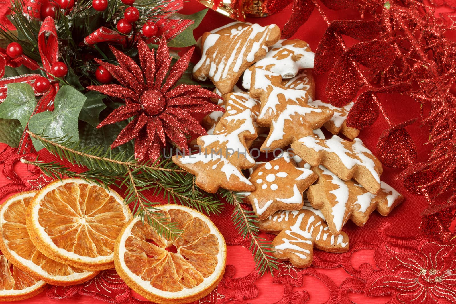 christmas background with needles. orange slices and gingerbreads on red