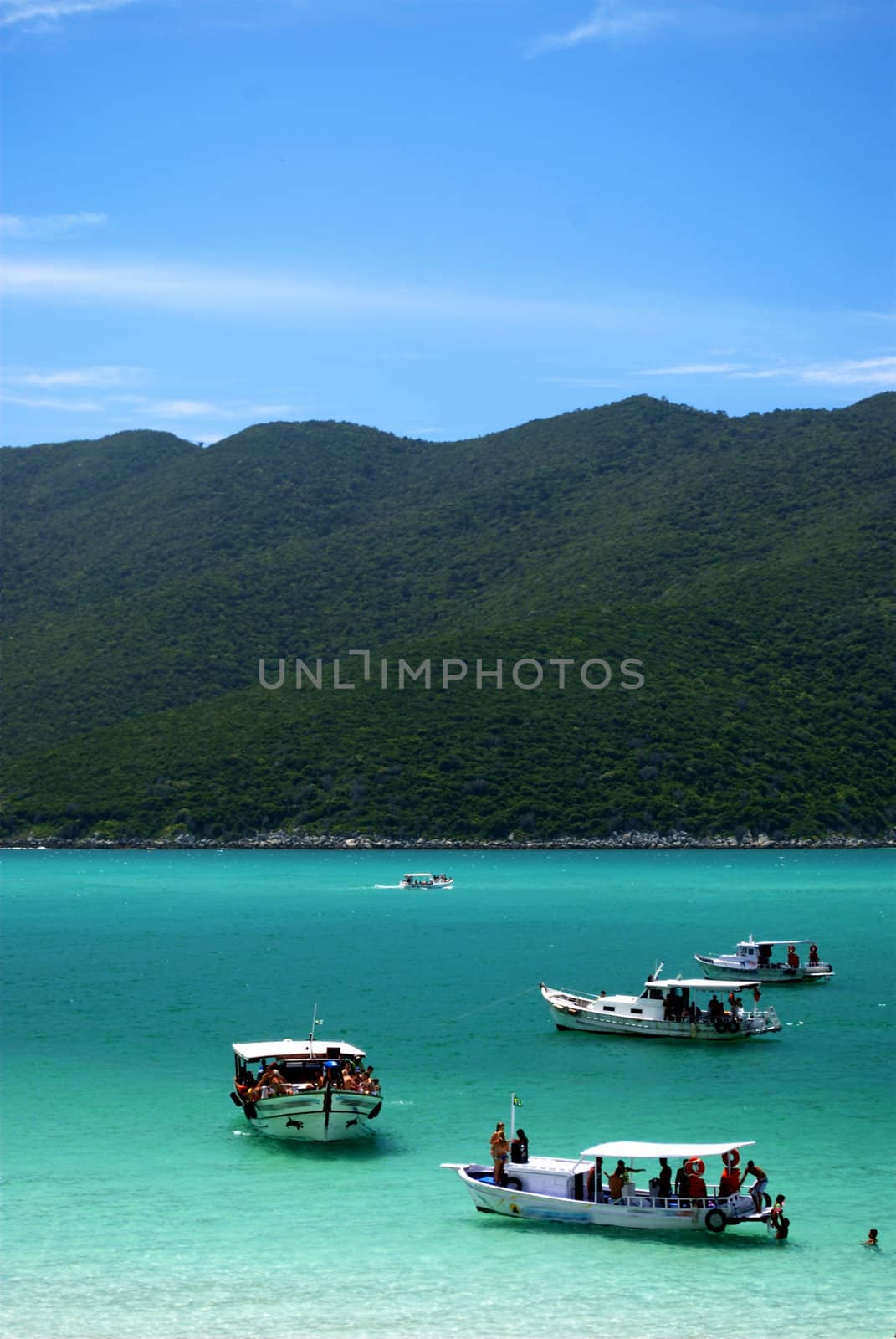 Boats over a crystalline turquoise sea in Arraial do Cabo, Rio de janeiro, Brazil