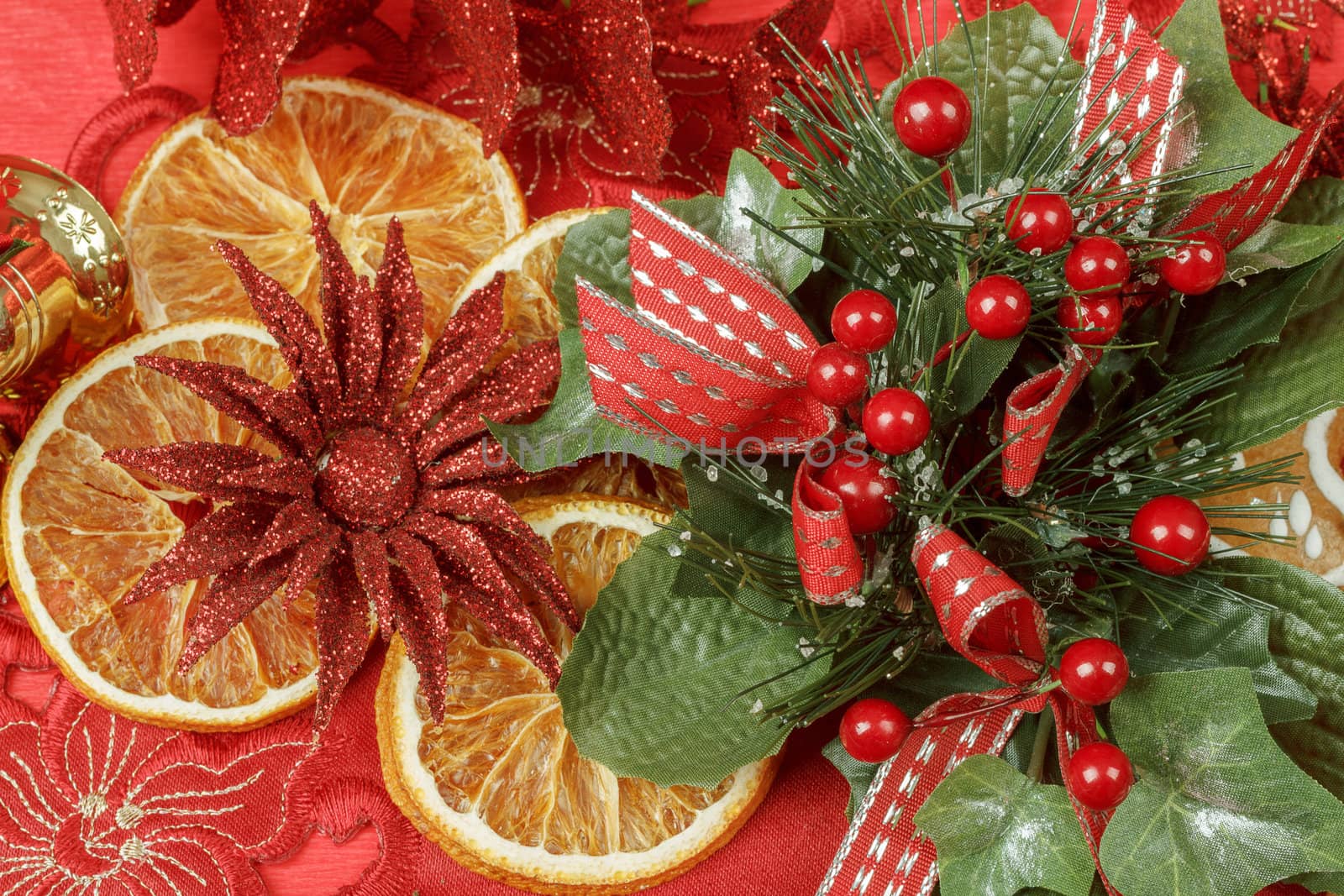 christmas background with needles. orange slices and gingerbreads on red
