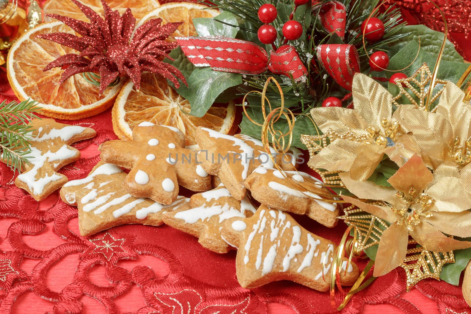 christmas background with needles. orange slices and gingerbreads on red