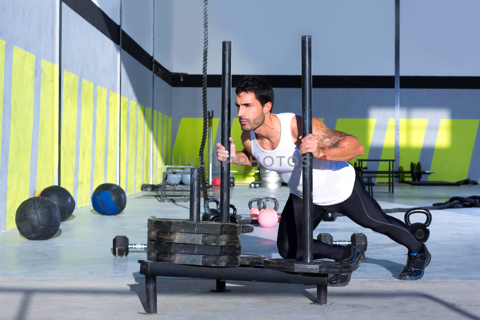 Crossfit sled push man pushing weights workout by lunamarina