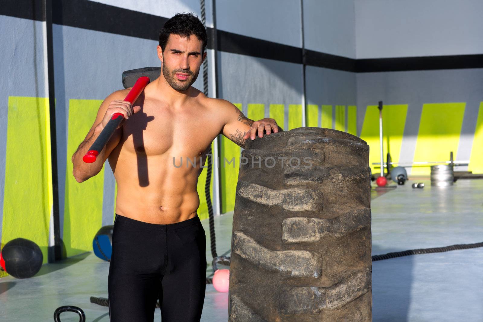 Crossfit sledge hammer man at gym relaxed by lunamarina