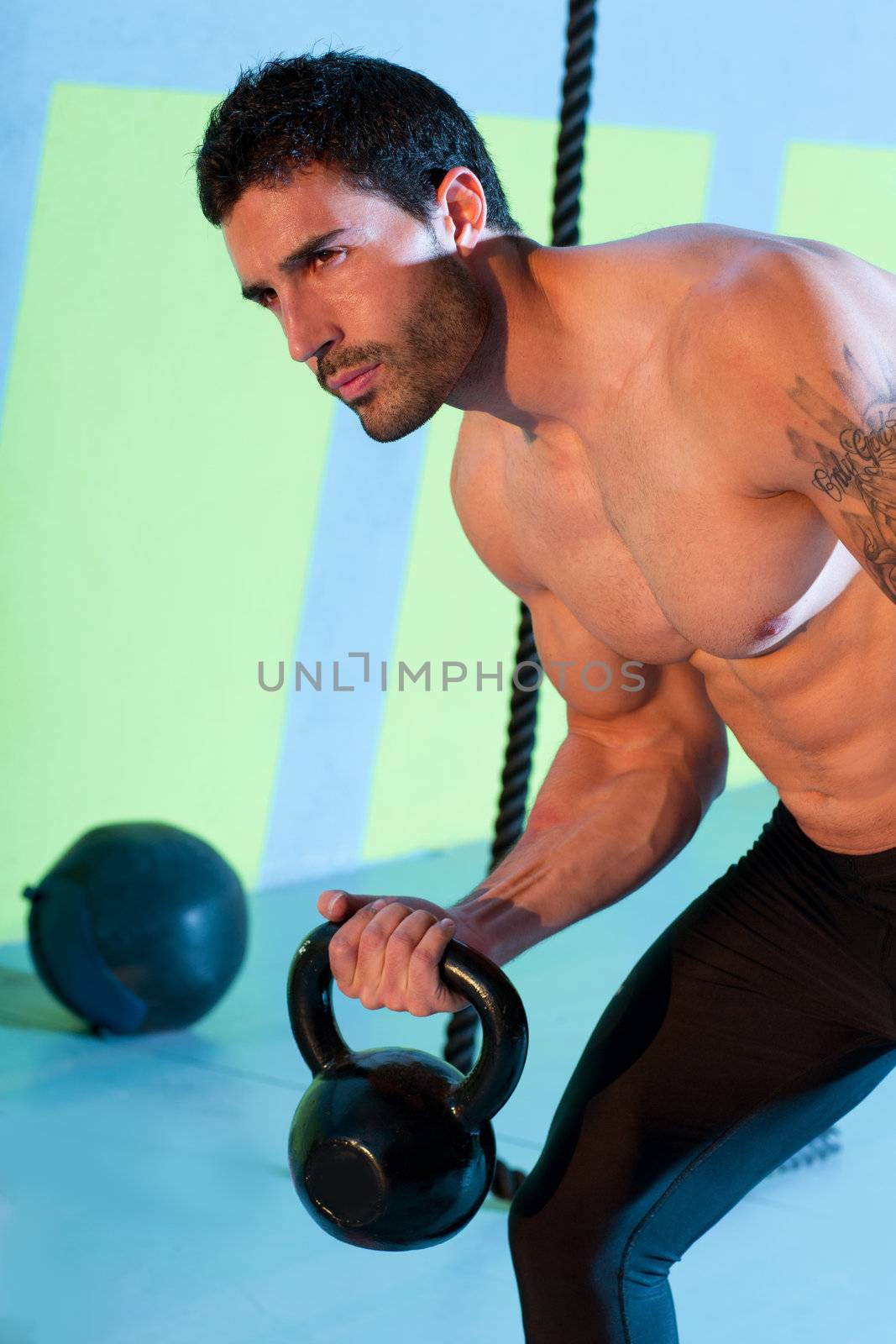 Crossfit man lifting kettlebell workout exercise at gym