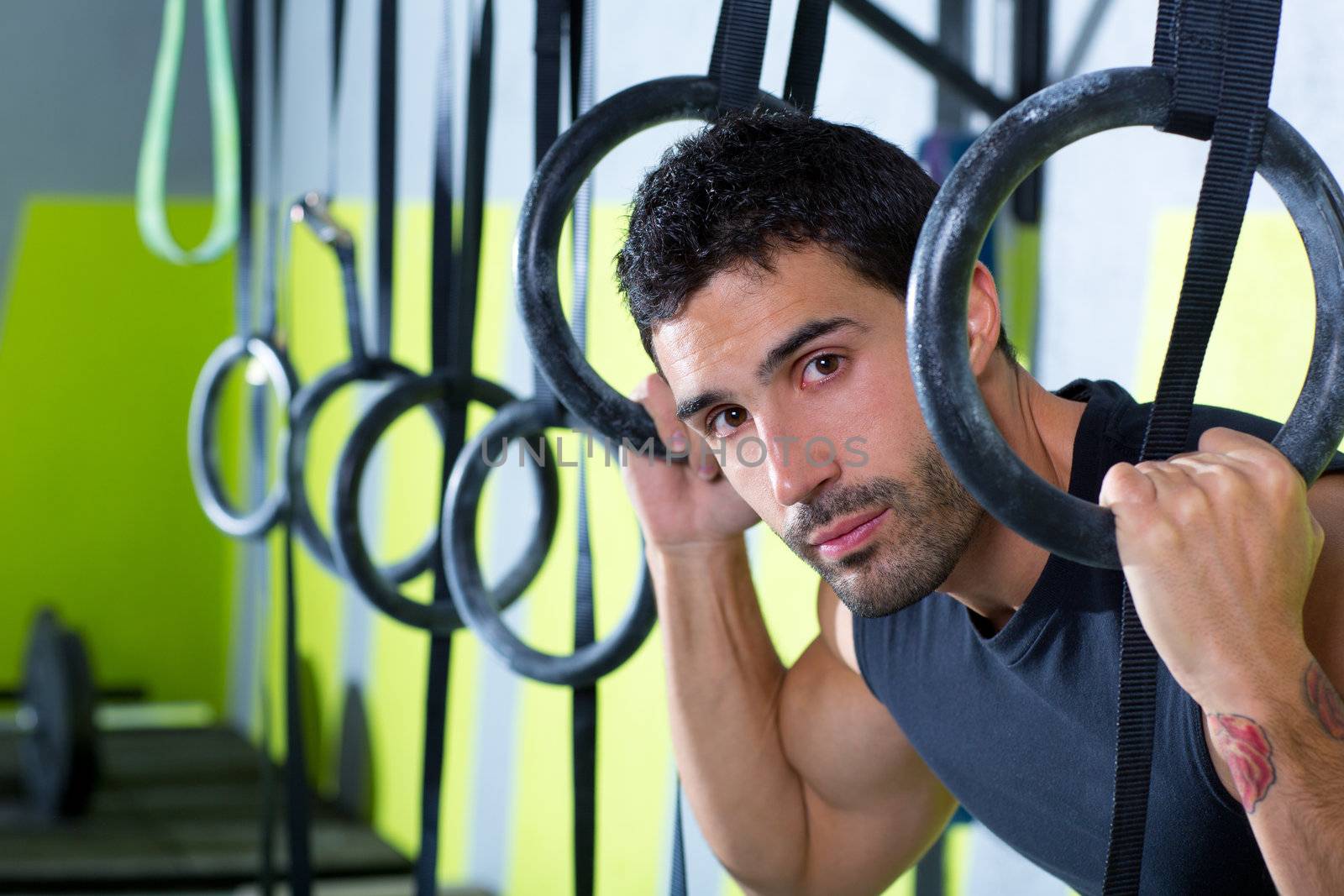 Crossfit dip ring man relaxed after workout at gym dipping exercise