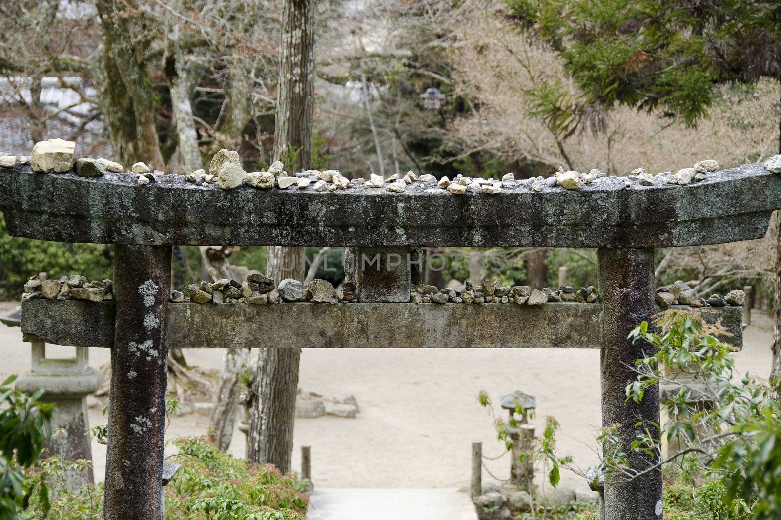 Stone torii gate in Japan with small stones on its top