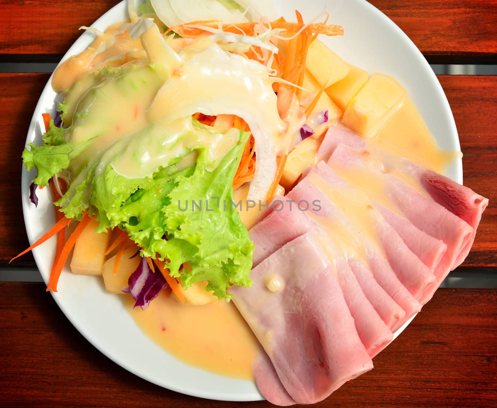 Ham with salad on wooden table