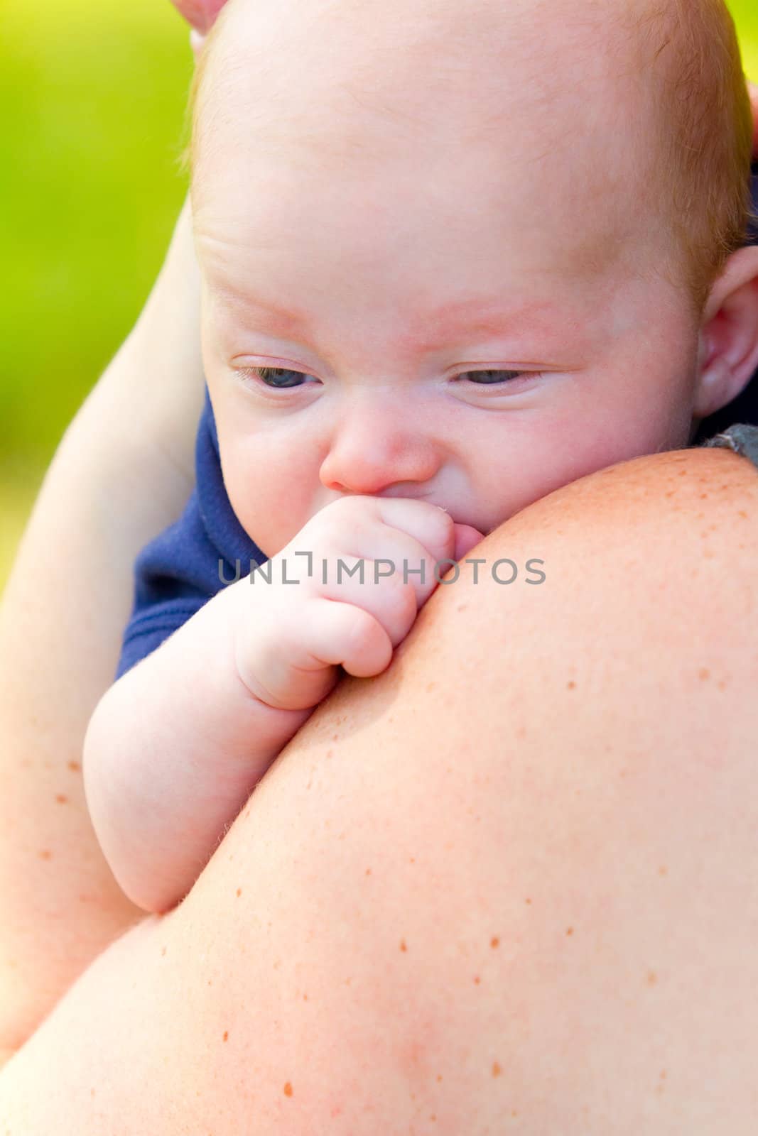 A newborn baby is looking around with his eyes open.