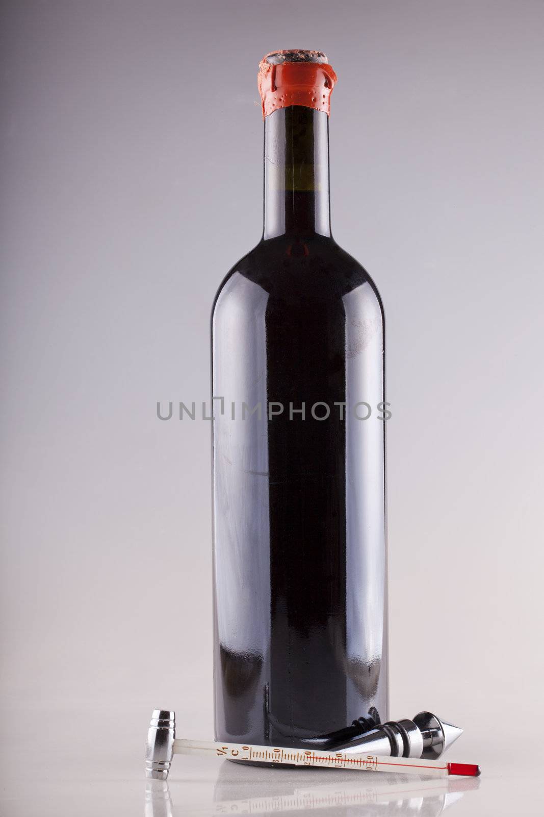 Red cap wine bottle with thermometer and other instrument