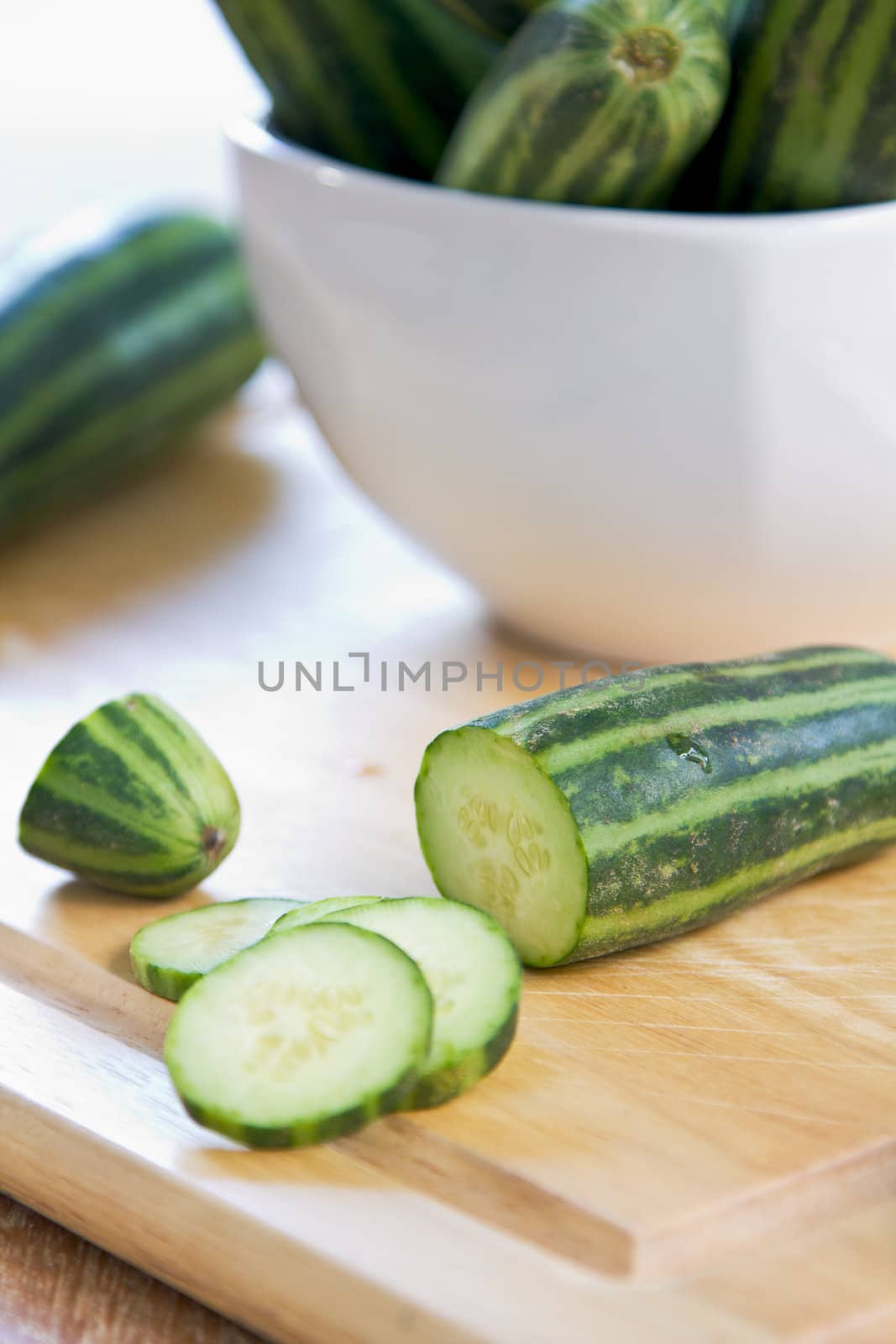 Fresh uncooked green stripe cucumber on chopping board