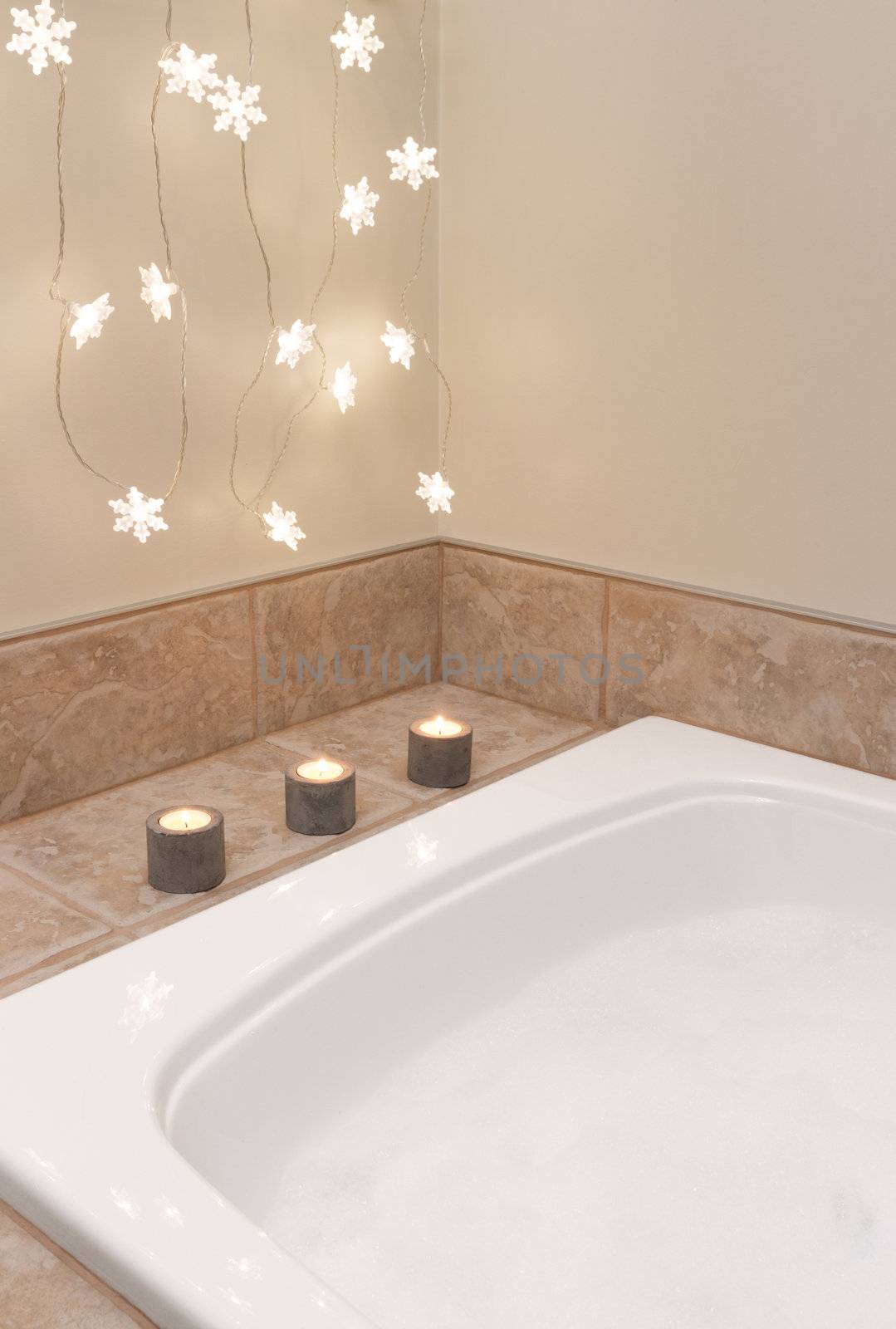 Bath with foam. Bathroom decorated with cozy lights and candles.