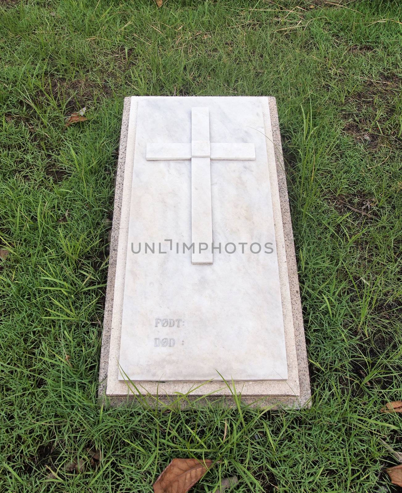 gravestone with christian cross and text space at cemetery