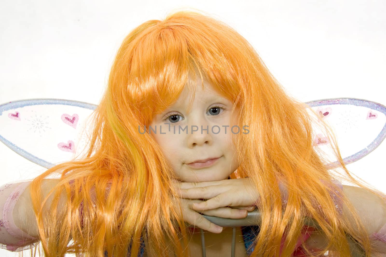 Girl in fancy dress and a wig on a white background