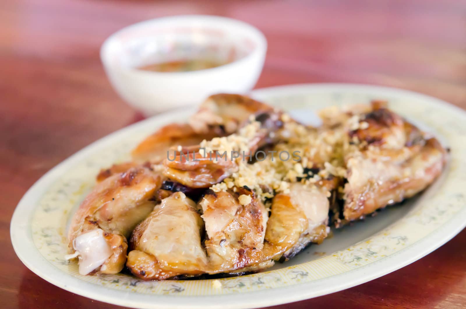 Grilled chicken with fried garlic on dish